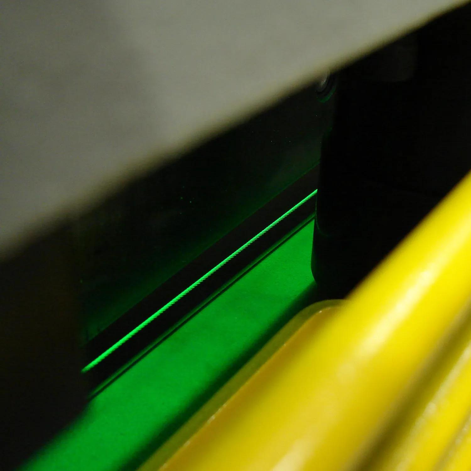 Green light projects shadow line on material